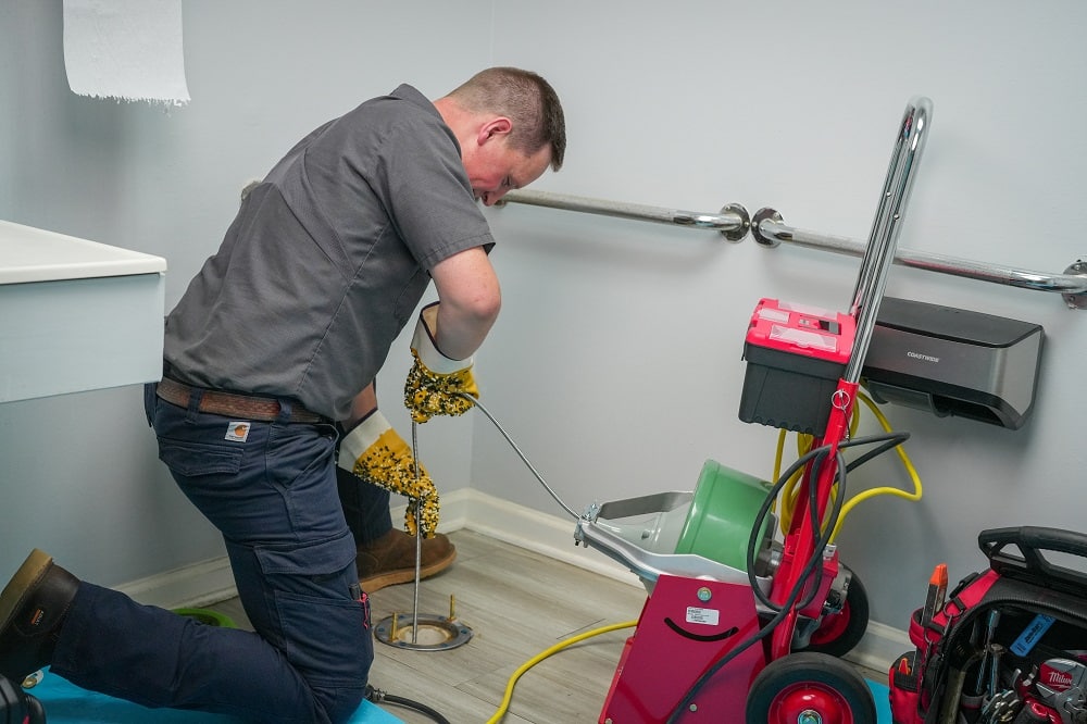 A technician uses advanced plumbing tools to inspect bathroom pipes with a camera device, as the monitor displays the pipe’s interior—improving repair accuracy.