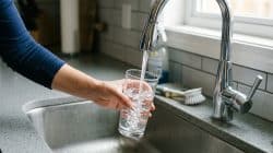 a man getting water from the faucet