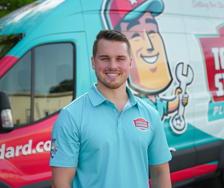 Kelton Balka standing in front of a van displaying the Tennessee Standard.