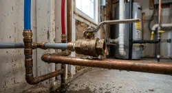 homeowner's residential main water shutoff valve being turned off during a plumbing emergency,