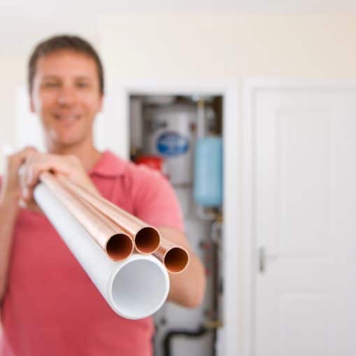 man golding a copper pipes and a PEX pipe