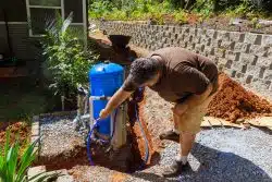 man working on filter for private well system