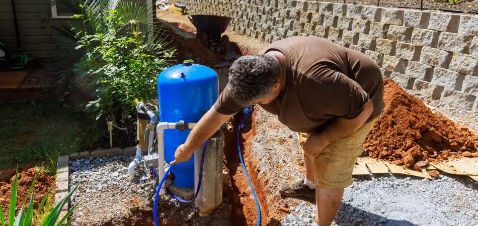 man working on filter for private well system