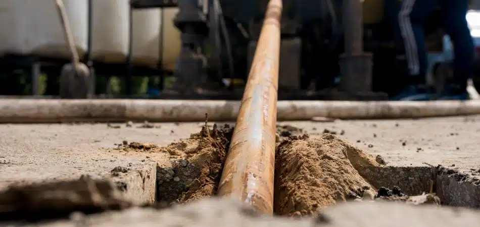 Low angle view of Horizontal directional drilling technology. Drilling machine work process. Trenchless laying of communications, pipes and water pipes. Close up