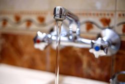 water runs from a tap into a kitchen sink