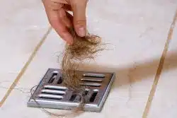 Removal of visible hair and debris on the shower drain.
