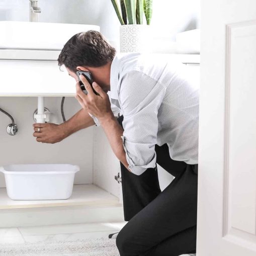 young man calling plumber for bathroom sink leak